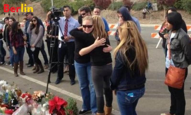 Amie Walker im Glas - umarmt von einem von Pauls Fans während der Gedenkfeier für ihren verstorbenen Bruder.